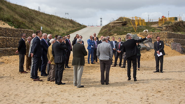A group of people on the Bacton beach, looking at the sandscaping project