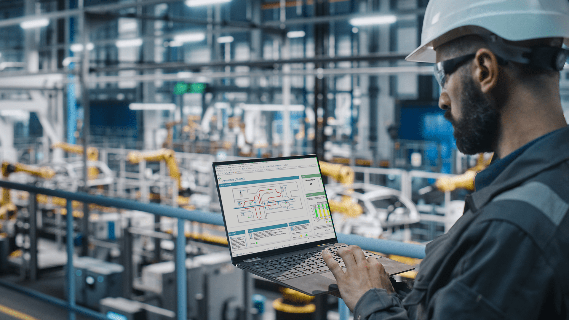 A plant manager uses Twinn Witness predictive simulation software while overseeing manufacturing operations